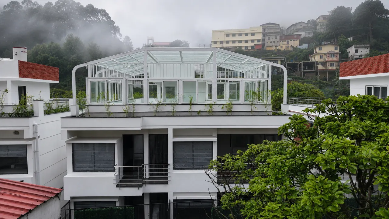The rooftop glass-house terrace above The Lovedale, wrapped in Kodaikanal mist