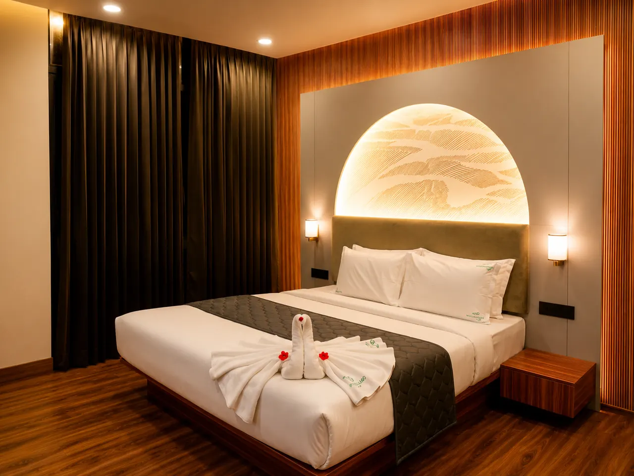 A premium king room with a dark wood accent wall and a backlit arched headboard