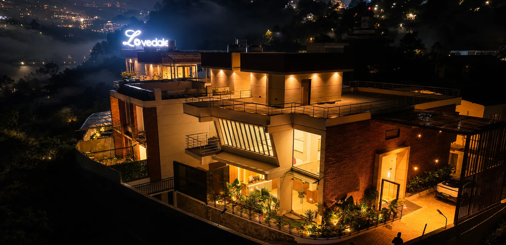 The Lovedale lit up at dusk above the misty lights of Kodaikanal