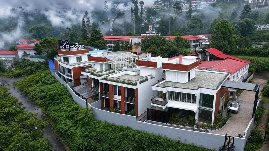 Aerial view of The Lovedale and its rooftop sign on the Kodaikanal hillside