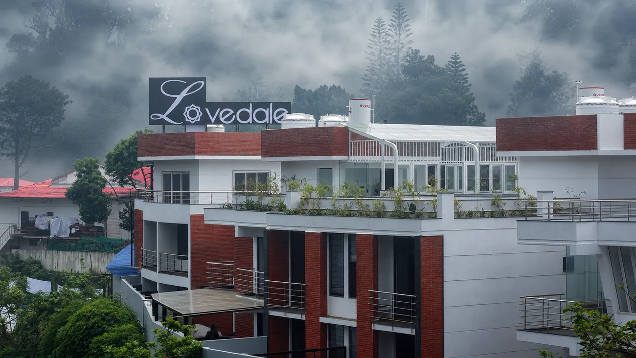 The Lovedale building and rooftop sign wrapped in the morning mist of Kodaikanal